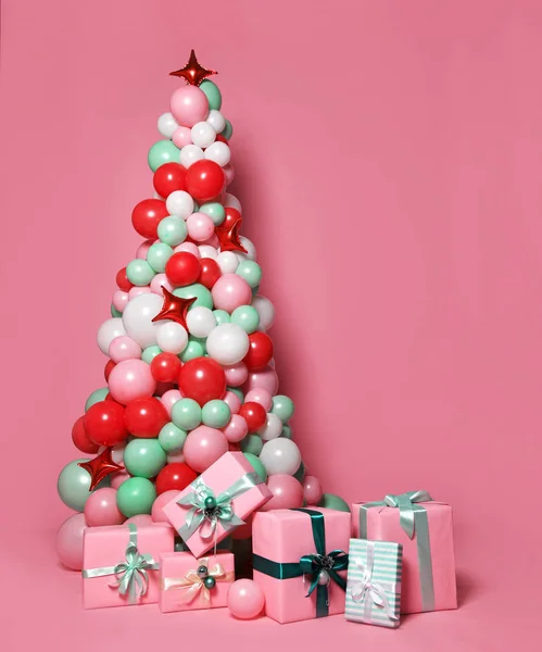 Χριστουγεννιάτικο δέντρο φτιαγμένο από πολλά παστέλ χρώμα μπαλόνια και δώρα ροζ παστέλ χρώμα παρουσιάσει κουτιά — Φωτογραφία Αρχείου