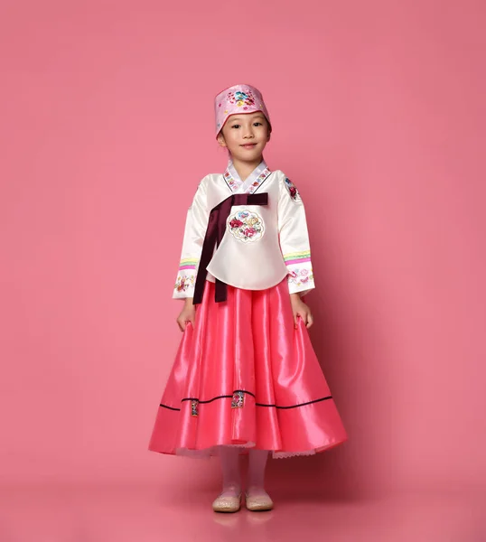 Bambina coreana in abito tradizionale di seta per la celebrazione del nuovo anno su rosa con le mani sparse — Foto Stock