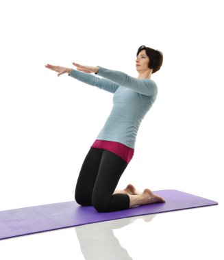 Kadın fitness eğitmeni germe yapmak için karın bar egzersiz jimnastik salonu iş izole üzerinde beyaz arka plan bacaklar eller. Anne Kadın Doğum sonrası egzersiz yaparken egzersiz