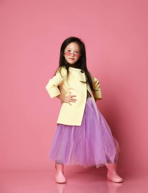 Küçük Asyalı kız sarı moda ceket Mor elbise ve modern kırmızı güneş gözlüğü poz