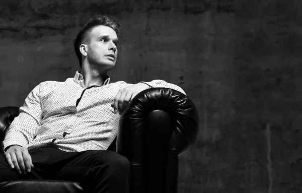 Jovem homem de negócios sentado no sofá cadeira Chester couro na camisa casual pensando — Fotografia de Stock