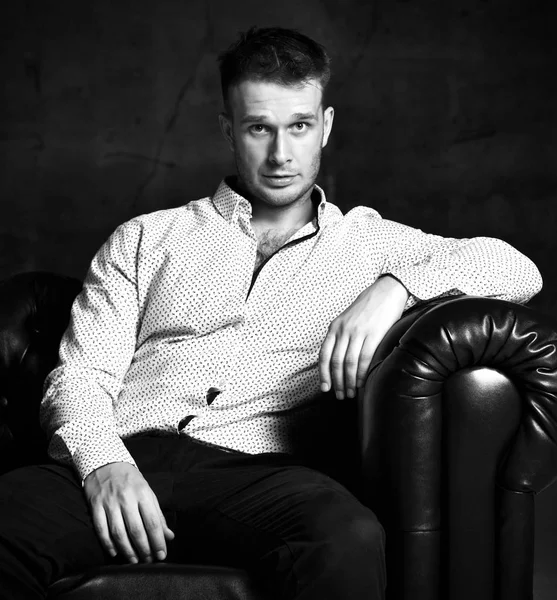 カジュアル シャツ思考の革チェスターのアームチェア ソファに座っている若手実業家 黒と白のイメージ — ストック写真