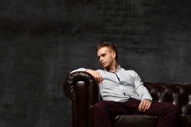 Deri Chester koltuk kanepe rahat gömlek düşüncesinde oturan genç iş adamı