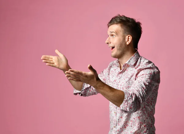 Young happy man in shirt talking stretching his arms gesticulate with hands smiling