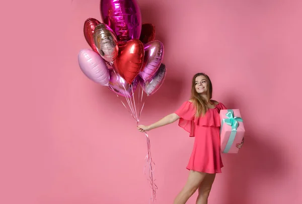 Valentine schoonheid meisje houdt rode en roze lucht ballonnen lachen op roze achtergrond Viering Valentines Day — Stockfoto