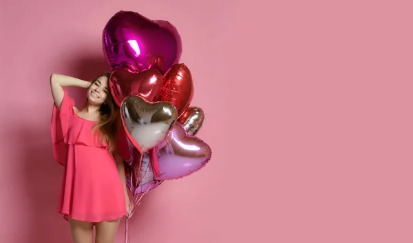 Valentine schoonheid meisje houdt rode en roze lucht ballonnen lachen op roze achtergrond Viering Valentines Day — Stockfoto