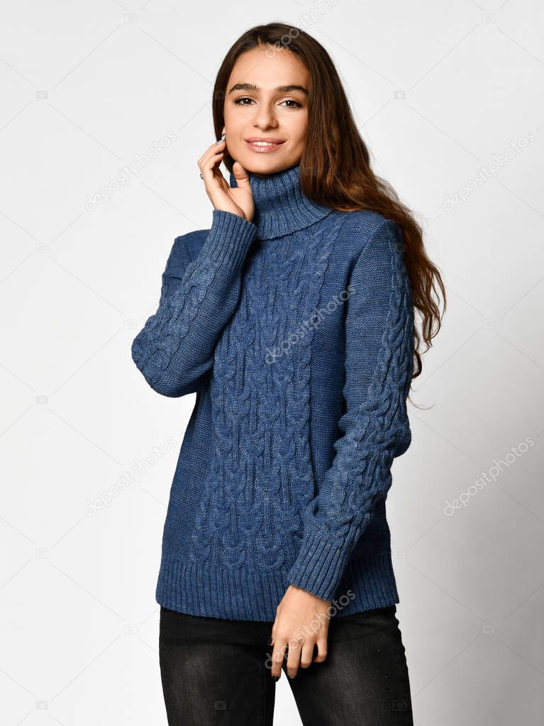 Young beautiful brunette curly woman posing in new casual blue blouse sweater 