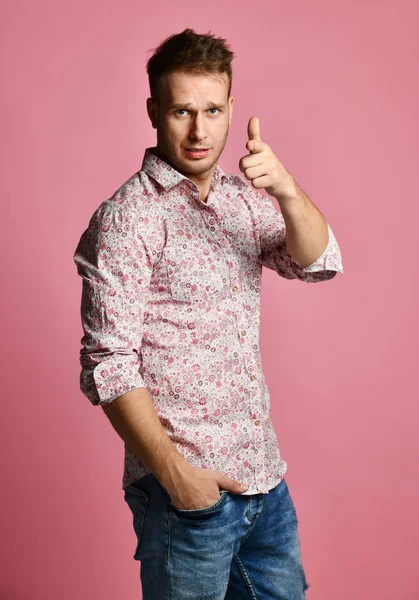 Young happy smiling man in shirt lucky winner pointing finger thumb up laughing shouting on pink — Stock Photo, Image