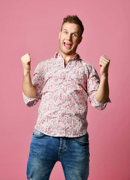 Joven feliz sonriente hombre en camisa afortunado ganador apuntando dedo pulgar hacia arriba riendo gritando en rosa —  Fotos de Stock