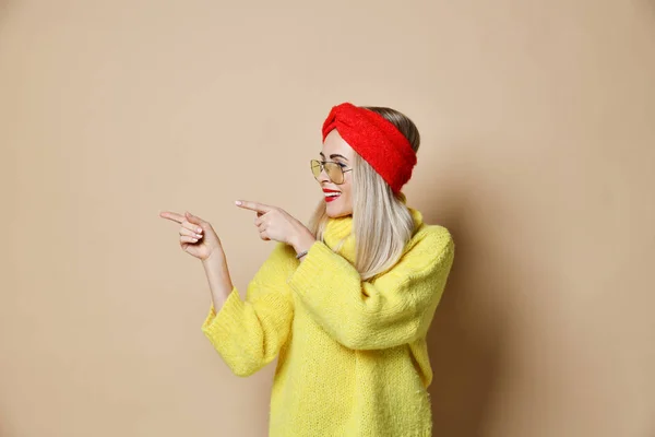 Mujer joven señala los dedos para la expresión del espacio de texto emoción en gafas de sol de moda suéter amarillo y labios rojos — Foto de Stock