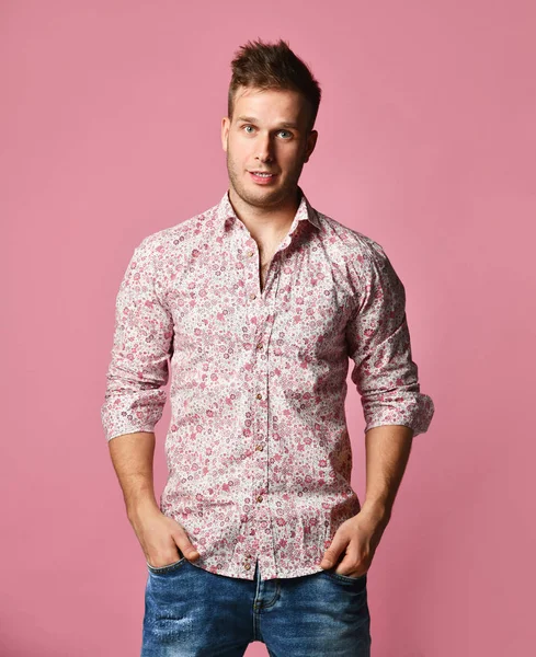 Jovem bem sucedido feliz sorridente homem de negócios em camisa e jeans azul em pé posando sobre fundo rosa — Fotografia de Stock