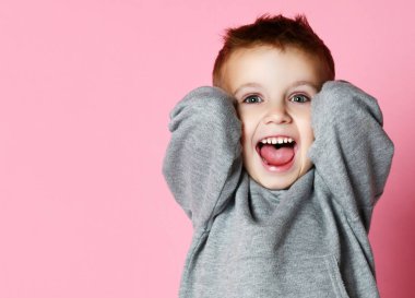 Bebek erkek çocuk kapsayan pembe üzerinde gülmekten çığlık elleri ile kulakları kapatın