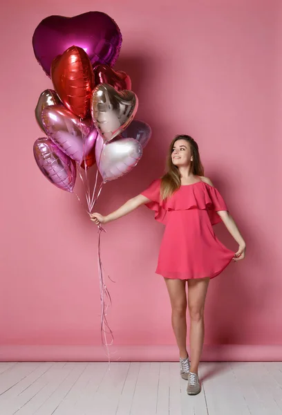 San Valentino Bellezza ragazza tenere palloncini d'aria rossi e rosa ridere su sfondo rosa che celebra San Valentino — Foto Stock