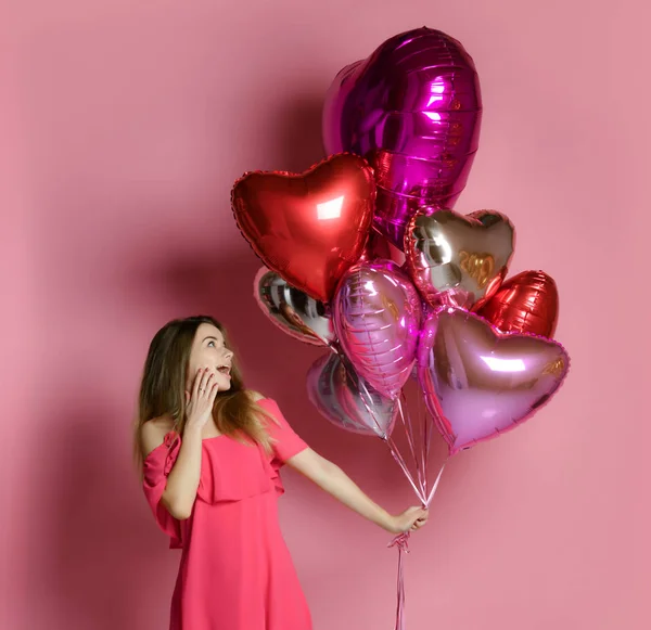 Valentine schoonheid meisje houdt rode en roze lucht ballonnen lachen op roze achtergrond Viering Valentines Day — Stockfoto