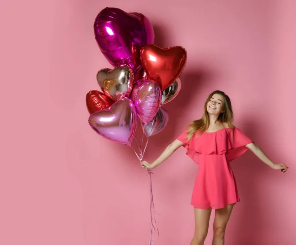 Valentine schoonheid meisje houdt rode en roze lucht ballonnen lachen op roze achtergrond Viering Valentines Day — Stockfoto