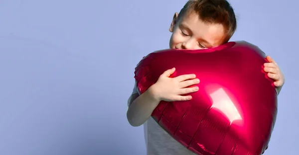 Kleine junge Liebe halten große rote Herz Ballon zum Valentinstag auf lila feiern — Stockfoto