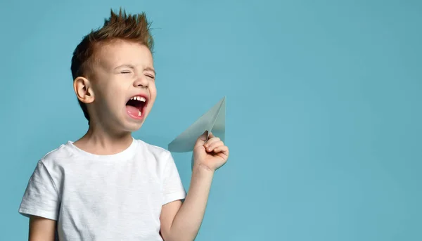 白い t シャツの若い赤ちゃん男の子子供保持青い緑のミントが叫んで紙飛行機折り紙叫び — ストック写真