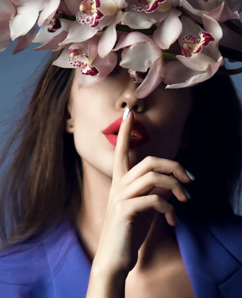 Gadis cantik dengan bunga anggrek. Model kecantikan wanita wajah di latar belakang ungu — Stok Foto