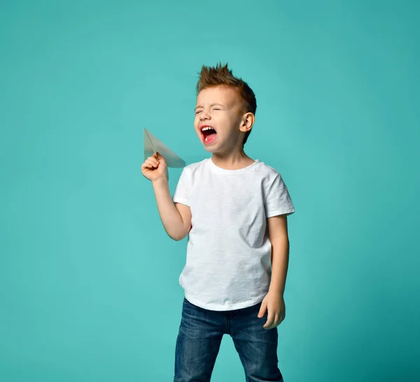 Niño listo para lanzar un avión de papel y gritar con los ojos cerrados. nuevo paso . — Foto de Stock