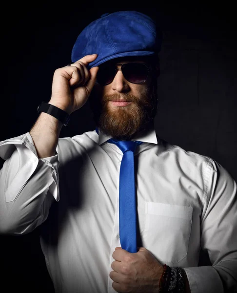 Caballero barbudo en camisa blanca y sunglesses sostiene su sombrero azul de la tapa y saludo de la corbata —  Fotos de Stock