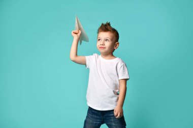 Kendine güvenen küçük çocuk oyun pilot bir kağıt uçak kalkışa hazır gökyüzü ve durumu değerlendirmek için arama yapar. güven. kalkış.