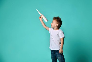 Küçük çocuk denize indirmek o ve gülümseme bir kağıt uçak inceliyor. Yeni bir başlangıç. kalkış.