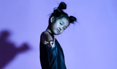 Asyalı çocuk kız gömlek ve pantolon ile yıldızlar ve beyaz spor ayakkabı eliyle ayağa kalkar ve sevinçle Not