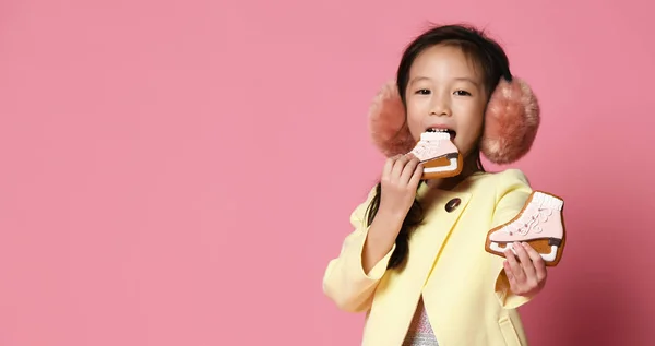 Küçük Asyalı kız sarı ceketli Doğum günü parti pembe üzerinde kutlamak için zencefilli kurabiye yemek — Stok fotoğraf
