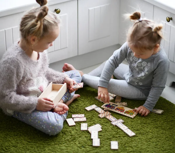 Iki çocuk kız kendi beyaz odasında yeşil halı eğitici bir oyun oynamak — Stok fotoğraf