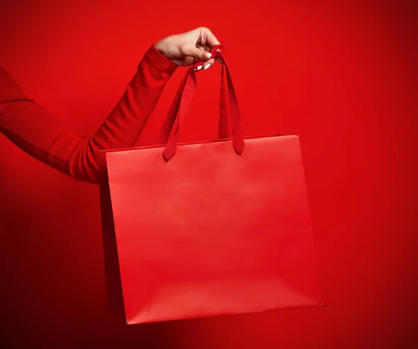 Hand van zakenvrouw houden rode boodschappentas — Stockfoto