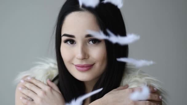 Close up portrait of woman open her eye with feathers falling down makeup — Stock Video