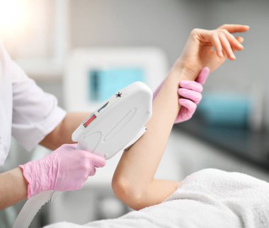 Eldiven performes hastanın yandan bir yordam içinde güzellik uzmanı ile tıbbi malzeme lazer donanımlı güzellik salonunda