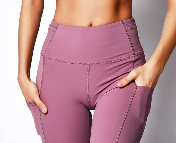 Cuerpo atlético de mujer de primer plano en pantalones de deporte en gris — Foto de Stock