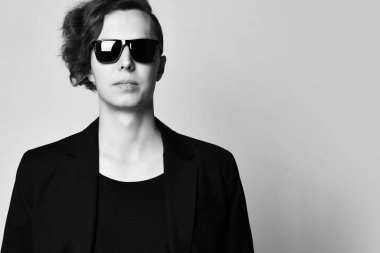 Closeup. Şık güneş gözlüğü, siyah t-shirt ve siyah ceket genç başarılı adam. Boş metin alanı.