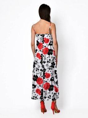 Yeni kırmızı çiçek desenli moda elbisesiyle poz veren güzel bir kadın.