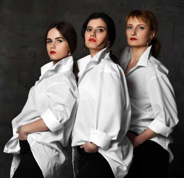 Team av tre brutala och snygga kvinnan i vita mens skjortor poserar som affisch av filmen eller musikbandet — Stockfoto