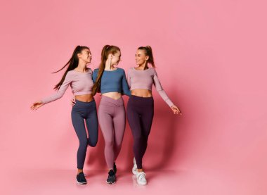 Yüksek teknoloji modern renkli spor üç güzel atletik kız şiddetle pembe sağlık yolunda birlikte yürümek