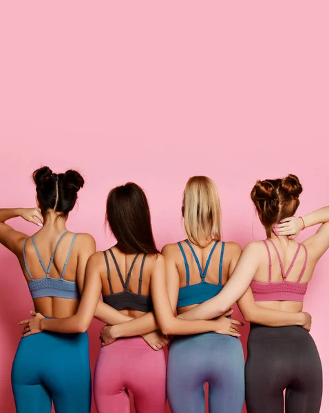 Спортивные девушки стоят спиной с хорошими ягодицами и инструментами для йоги. — стоковое фото