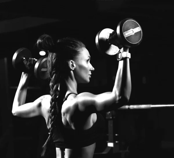 Sportowa młoda kobieta pracuje z hantlami wagi w siłowni. Koncepcja odchudzania i diety — Zdjęcie stockowe
