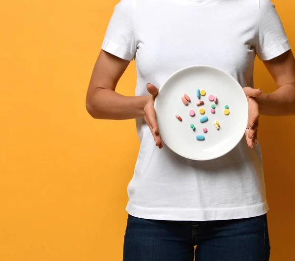 Mujer nutricionista mano mantenga placa blanca con diferentes píldoras de color de la tableta suplementos dietéticos prescripción de medicamentos para bajar de peso — Foto de Stock
