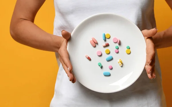 Mujer nutricionista mano mantenga placa blanca con diferentes píldoras de color de la tableta suplementos dietéticos prescripción de medicamentos para bajar de peso — Foto de Stock