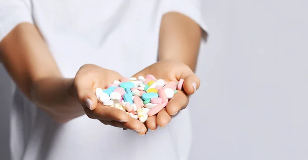 クローズ アップ。異なる色の錠剤の丸薬を持つ女性のハート型の手のひらは、処方減量薬を補う — ストック写真