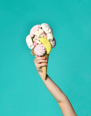 Mavi nane lezzetli ahududu marshmallow marmelat ile waffle koni büyük dondurma tutan bebek kız el