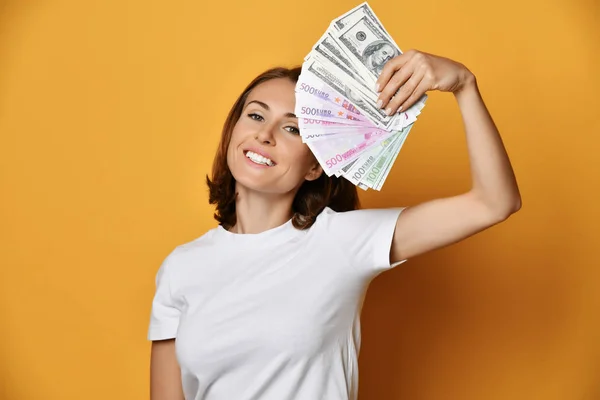 Happy smiling woman in white t-shirt holds a fan of banknotes cash — Stock Photo, Image