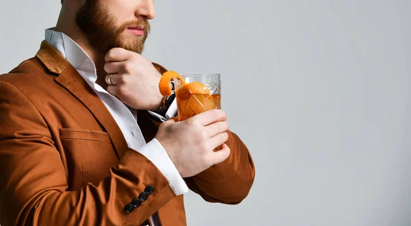 Young business man in white shirt and jacket drinking red martini cocktail drink with orange in rocks glass — Stock Photo, Image