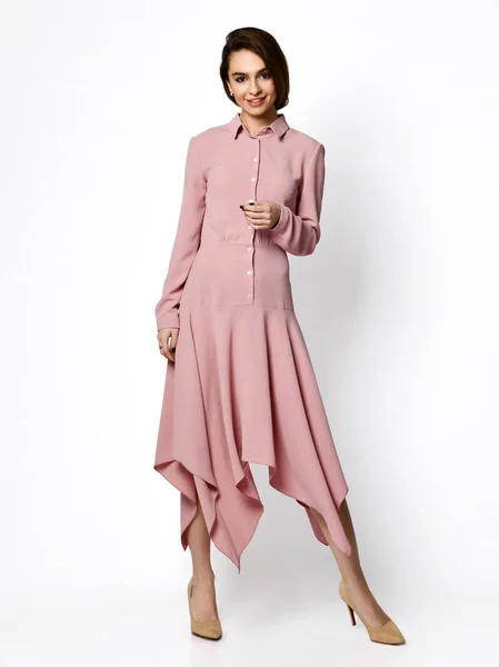 Young beautiful woman posing in new fashion casual pink winter dress smiling on white — 스톡 사진