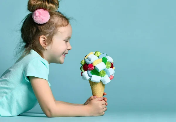 Retrato de niña feliz niño sosteniendo helado grande en cono de gofres con sabrosos ingredientes mermelada de malvavisco de bayas —  Fotos de Stock