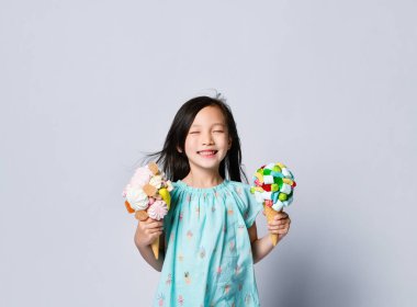Joyfull komik asya kız bebek çocuk lezzetli topingler ile waffle koniler onu büyük dondurma bir çift yakın tutar