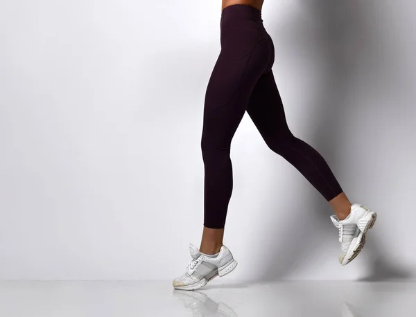 Deportiva piernas de mujer caminando en ropa deportiva en un blanco —  Fotos de Stock