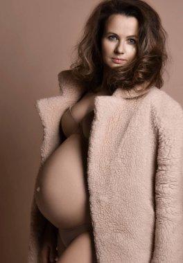 Bej üzerinde moda kürk ceket güzel genç hamile mutlu anne kadın 